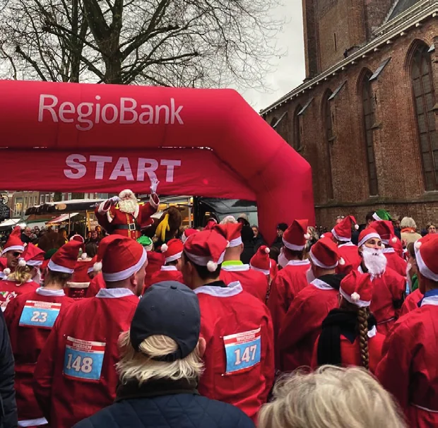 Een grote groep deelnemers bij de start van de Santa Run